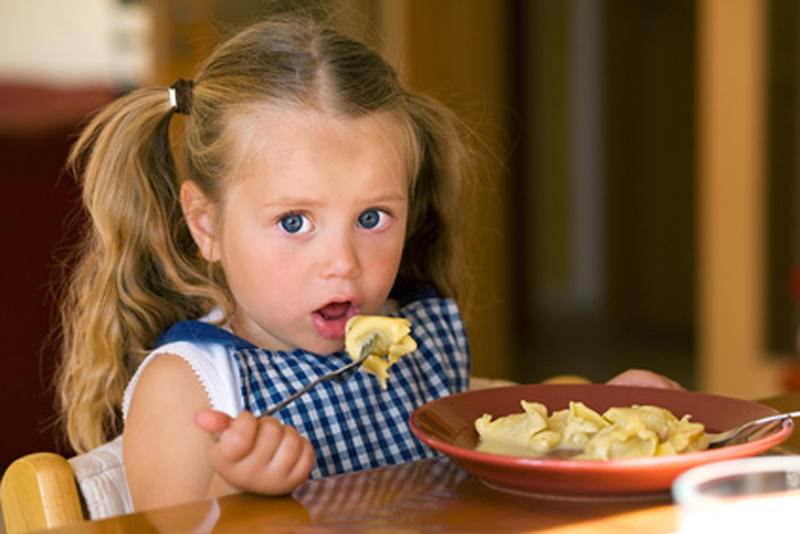 Mädchen beim Essen von Pasta